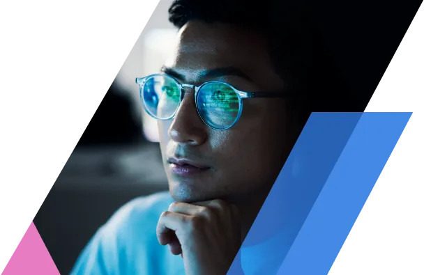 Business professional standing in a server room holding a laptop